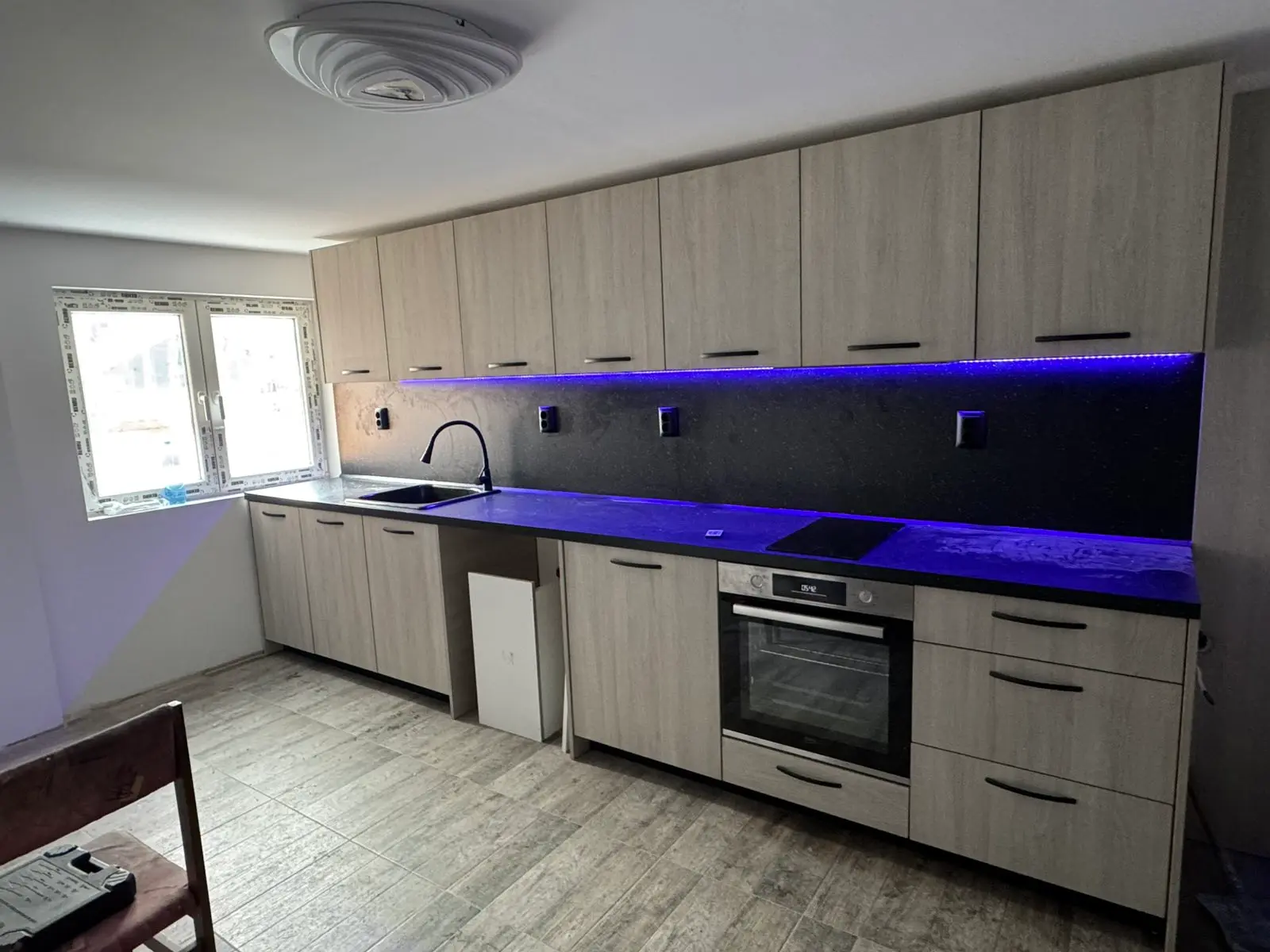 Г-образна бяла кухня по поръчка с дъбов плот и LED осветление — проект Бургас