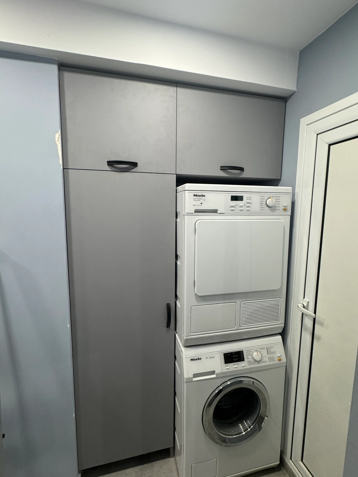 Шкаф по поръчка за перална и сушилня в сиво с горни шкафове — проект Бургас